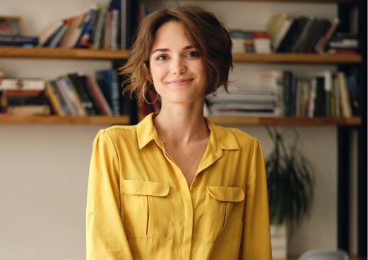 Smiling professional woman standing in front of a bookshelf